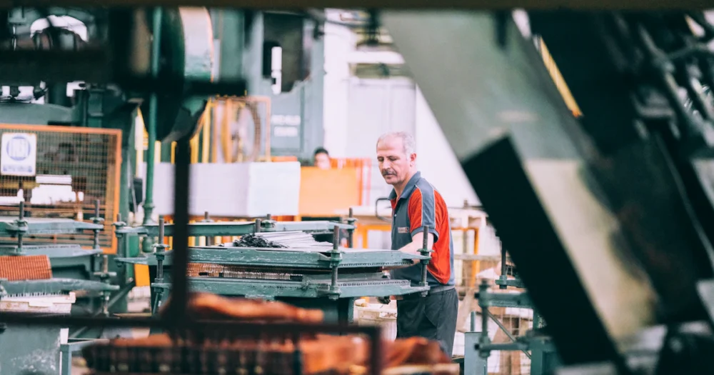 Operatör arbetar vid en industrimaskin i en fabrik